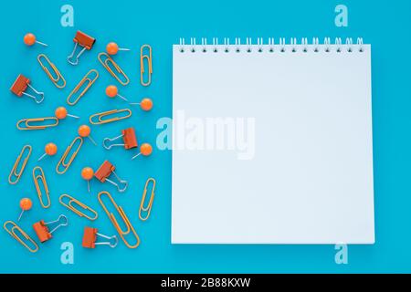 Empty spiral notebook and clips on blue background. Copy space. Education, planning concept. Copy space Stock Photo