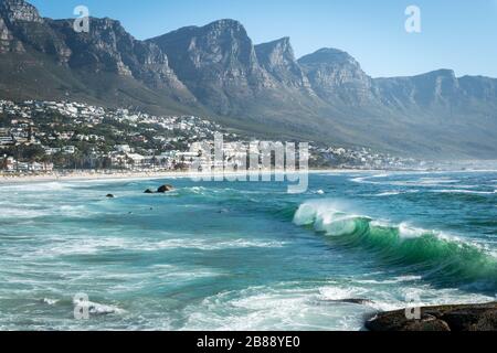 Cape Town, South Africa - November 25, 2019 - waves in Atlantic ocean on Camps Bay Beach and Twelve Apostles Mountain Chain Stock Photo