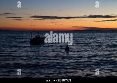 Orange sunset over the Adriatic sea in Croatia with small boat. Stock Photo
