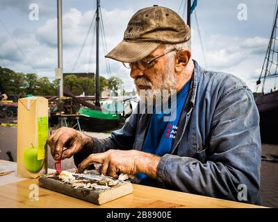 Amsterdam, Septeember 2018 - portrait of an old worker eating traditional herring with oil covered hands. This gentleman was probably working in saili Stock Photo