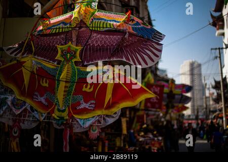 Colourful dragon patterned traditional delta shaped kites in a market in China. Stock Photo