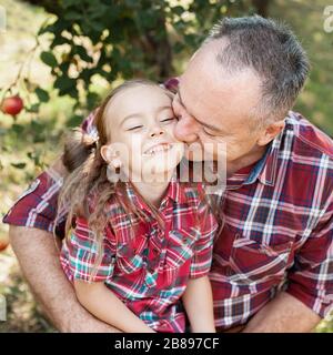 grandfather with granddaughter. Love you so much my grandpa. Grandpa kissing grandchild in thr park. Multi generation family enjoying in the park. Stock Photo