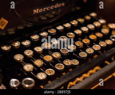 An old black metal typwriter with close up on letters from keyboards with vintage patina. Stock Photo