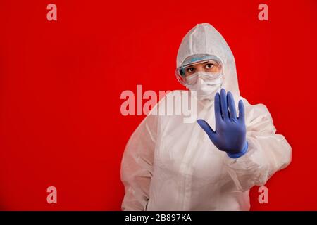 A doctor indicates stopping the spread of the COVID-19 virus. The concept of preventing the spread of the epidemic and treating coronavirus. Coronavirus treatment. Stock Photo