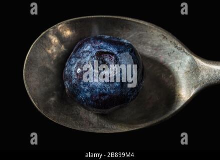 Frozen blueberry on teaspoon. Stock Photo