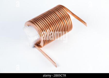Close-up flat twisted copper wire on a plastic bung on a white surface. Concept of small parts for the manufacture of household appliances and powerfu Stock Photo