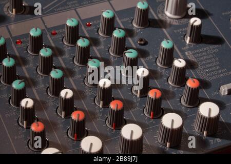 Panorama close-up buttons equipment for sound mixer control. Mixer for musician DJ and sound engineers. Mixing DJ remote with colorful neon light. Nig Stock Photo