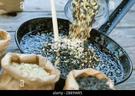 Homemade fat fodder, ingredients: hardened coconut oil, sunflower seeds, peanuts, seed mix and sunflower oil was melted and seed mix added, Germany Stock Photo