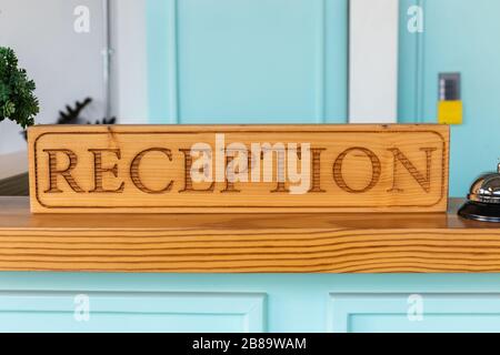 wooden reception desk sign on front of counter in hotel Stock Photo