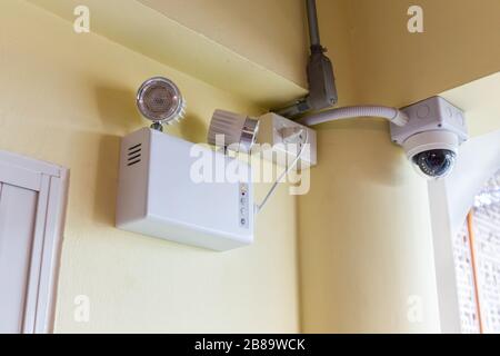 Emergency lights and security surveillance cameras are installed on the ceiling of the building. Stock Photo
