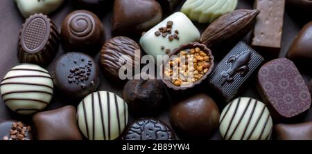 A chocolate panorama of fancy filled chocolate with caramel, nuts, creams and coffee Stock Photo