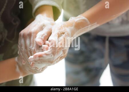 Boys Washing hands with foam soap to be protected against covid Stock Photo