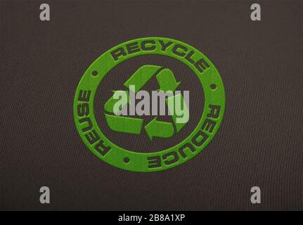 Recycle logo embroidered on cloth background. Stock Photo