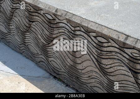 An interesting wavy line pattern on a cement wall. Bokeh effect and available copy space. Stock Photo