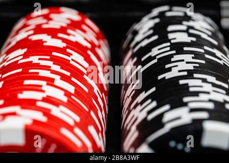 A macro of two rows of betting chips. one red and one black row with the side spots in random patterns.  Medium macro depth of field.  Vivid contrast Stock Photo
