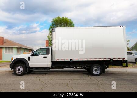 An unbraded commercial grade and heavy duty moving truck or furniture delivery vehicle parked infront of a residential home. Stock Photo