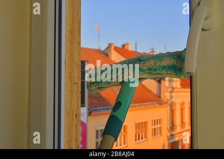 Cleaning windows with a squeegee. Cleaning concept. Washing window, close up. Looking through window. Stock Photo