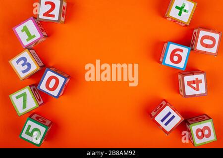 Wooden cubes with numbers on an orange background top view close-up Stock Photo