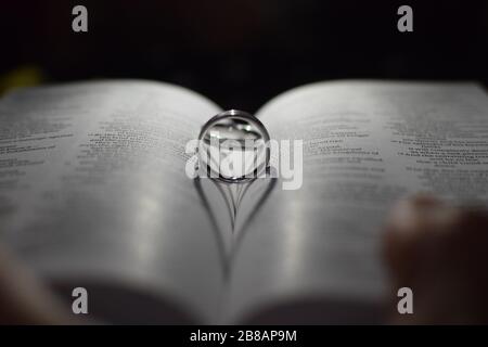 Wedding rings on a bible with shadow forming a heart shape Stock Photo