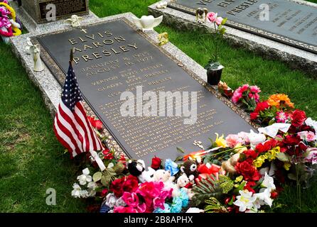 Memphis, Tennessee, United States - July 21 2009: The Grave of Elvis Presley in Graceland decorated with Flowers and a Flag. Stock Photo