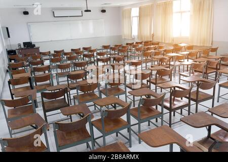 Empty classroom with a lot of chairs with no student. Empty classroom with vintage tone wooden chairs. Back to school concept. Stock Photo