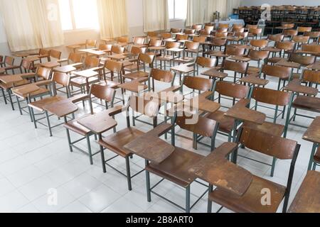 Empty classroom with a lot of chairs with no student. Empty classroom with vintage tone wooden chairs. Back to school concept. Stock Photo