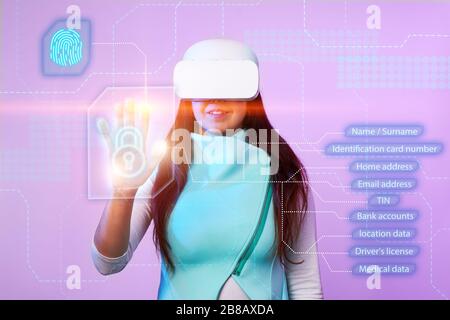 Woman is using vr headset to access for personal data. Concept of using future technology for cybersecurity, protection personal data. Stock Photo