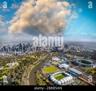 Aerial city and stadiums view from helicopter at sunset, Melbourne. Stock Photo
