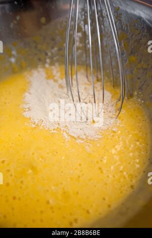 Whipping yellow cream with a whisk close up Stock Photo