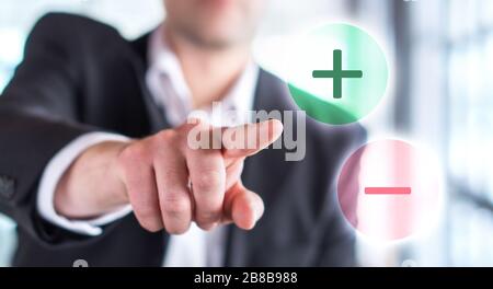 Pros and cons concept. Business man touching plus or minus symbol. Choosing between two options. Stock Photo