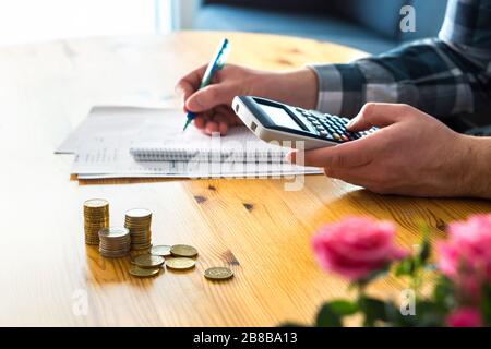 Man using calculator and counting budget, expenses and savings. Low income family living cost and rising prices concept. Calculating and budgeting. Stock Photo