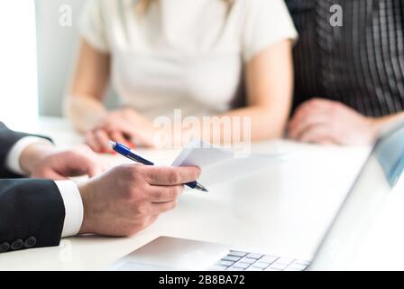 Couple having meeting with legal advisor, real estate agent, businessman or banker. Lawyer giving advice or consultant showing document or agreement. Stock Photo