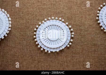 Pin set for sewing on dark canvas texture background. Tools and accessories florists snd sewing. Stock Photo