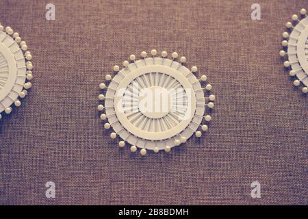 Pin set for sewing on dark canvas texture background. Tools and accessories florists snd sewing. Stock Photo