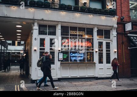 London, UK - March 06, 2020: Facade of Genuine Liquorette bar in Soho, an area of Central London famous for bars, cafes and restaurants, people walkin Stock Photo