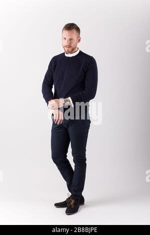 Image of handsome cheerful young man standing and smiling isolated over white wall. Looking in the camera. Stock Photo