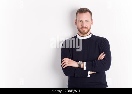 Image of handsome cheerful young man standing and smiling isolated over white wall. Looking in the camera. Stock Photo