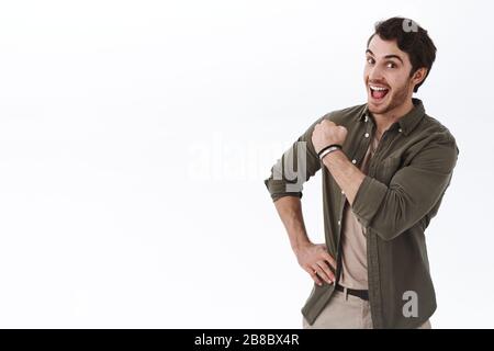Optimistic happy and active young man encouraging keep going, fist pump cheerfully and smiling, boosting confidence, showing enthusiasm, inviting come Stock Photo