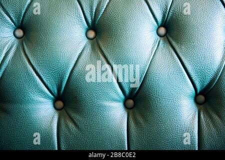 Green leather chesterfield sofa upholstery. Close up texture detail background. Stock Photo