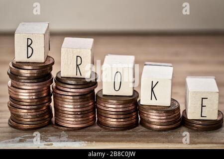 Wooden cubes with the word broke and pile of coins, money climbing stairs, business concept Stock Photo