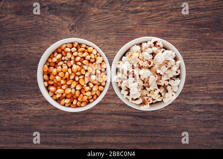 Two bowls filled with popcorn and corn maize or kernel seed. Popcorn preparation. Stock Photo