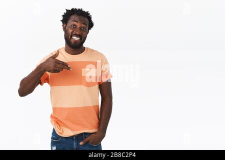 Confident, sassy young handsome african-american beared guy pointing himself with pleased, proud smile, telling about himself, bragging or boastfully Stock Photo