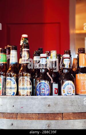 February, 2020 - Ankara, Turkey: Variety of empty beer bottles with different brands displayed in a pub counter. Close up view. Stock Photo