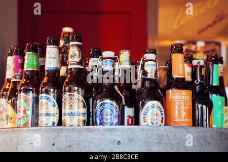 February, 2020 - Ankara, Turkey: Variety of empty beer bottles with different brands displayed in a pub counter. Close up view. Stock Photo