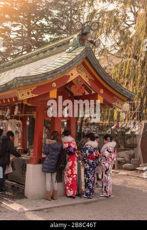 tokyo, japan - january 28 2020: Japanese women in kimono who purify themselves with temizuya water before praying in the Asakusa shrine. Stock Photo