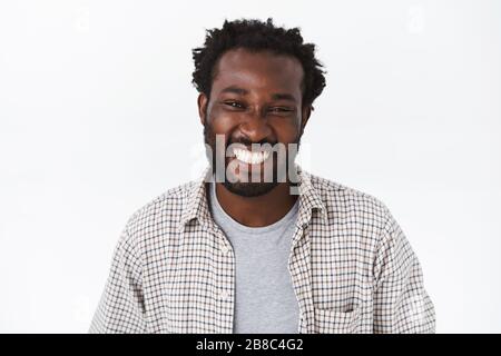 Close-up portrait, handsome cheerful young african-american bearded man in checked shirt, grey t-shirt, laughing and smiling camera entertained Stock Photo