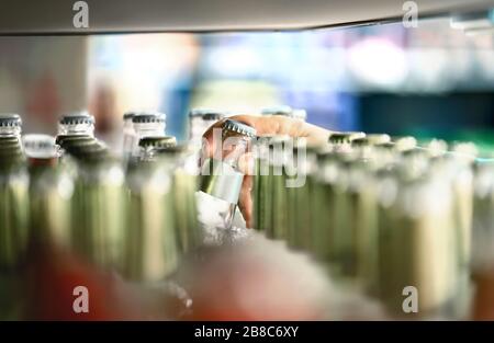 Close up of drink shelf in supermarket. Alcohol, soda, sodapop, mineral water or ginger ale bottle. Customer buying product in grocery store. Stock Photo