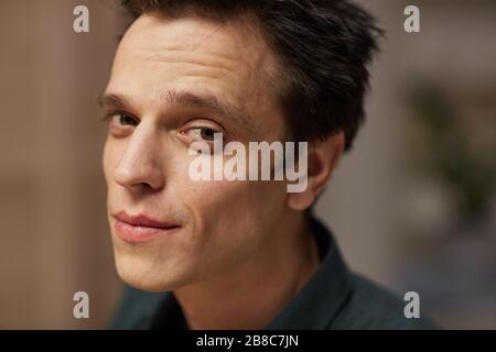 Portrait of young handsome man with dark hair looking at camera Stock Photo