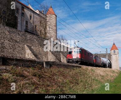 Freight train going through the medieval gate of the Grandson Castle, Canton of Vaud, Switzerland. Stock Photo