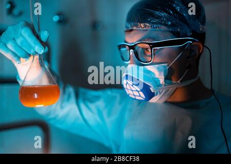 Young male researcher carrying out scientific experiment.